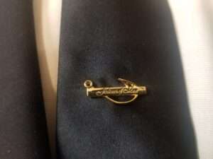 Fishers on men gold pin on black suit