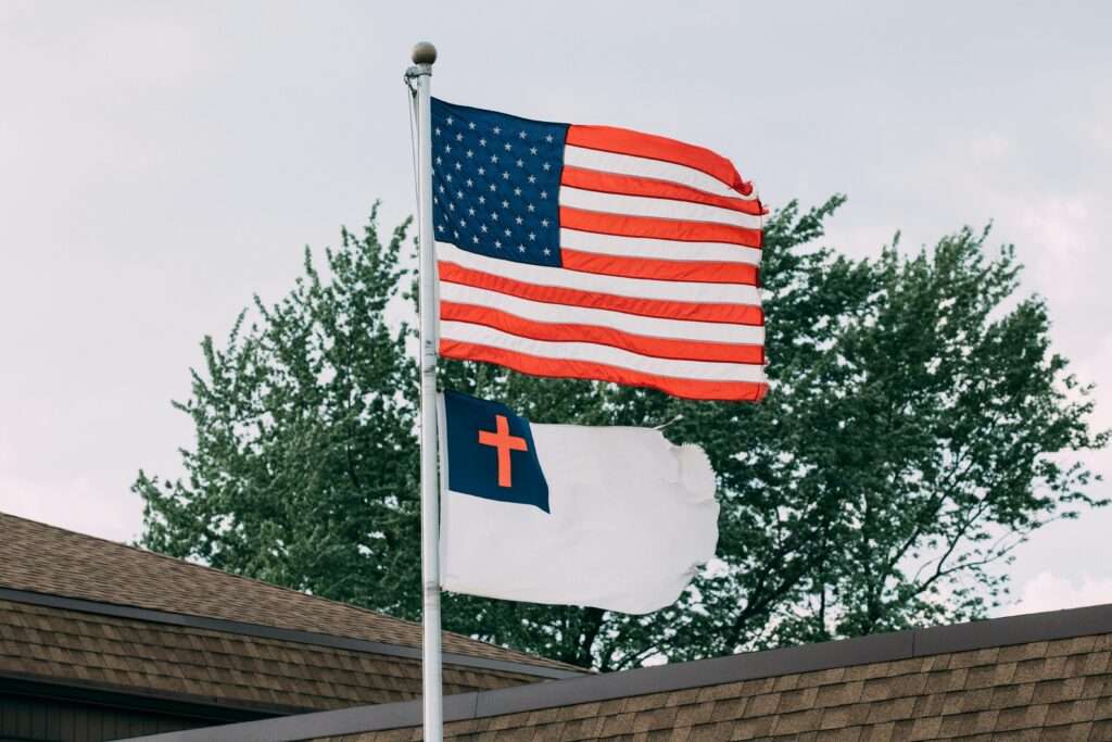 Patriotic display of American and Christian flags on rooftop in Springfield, IL.